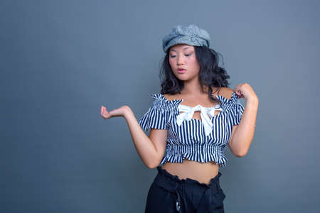 Young Chinese girl posing for the camera on a gray backgroundの写真素材