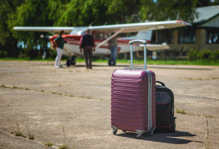 close-up of luggage on the runway, aircraft in the background out of focus, passengersの写真素材