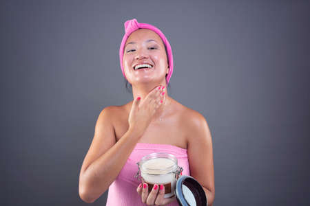 young chinese woman taking care of her facial skinの写真素材