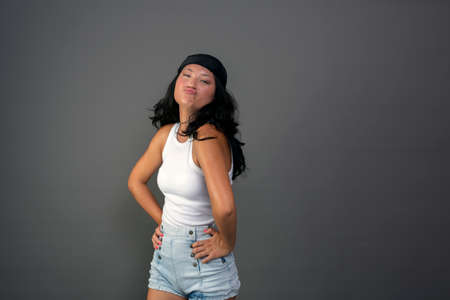 pretty young woman with bandana making funny gestureの写真素材