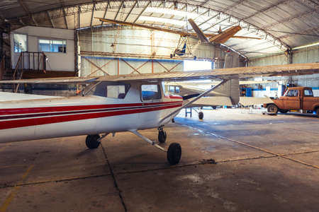 photo of old hangar with airplanes and old truck.