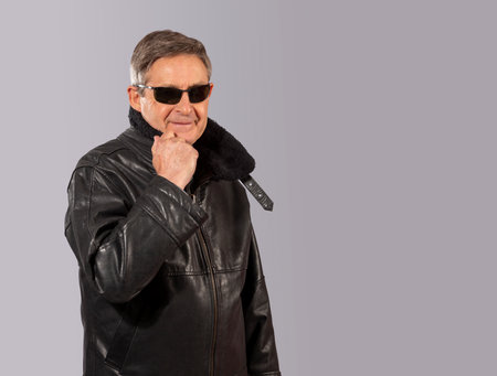 attractive elderly man with black leather jacket and sunglassesの写真素材