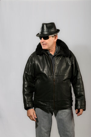 elderly man with sunglasses, hat and black leather jacketの写真素材