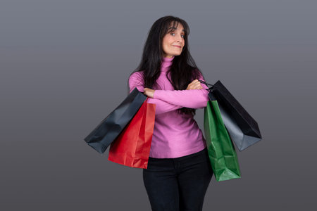 cute brunette woman with gift bags and funny expressionの写真素材