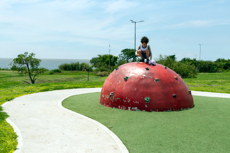 photo of child on top of children's climbing semi-sphereの写真素材