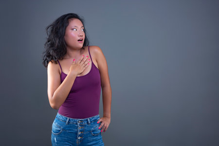 Portrait of a beautiful Asian woman wearing purple top and jeans.の写真素材