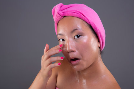 beautiful asian ethnicity woman cleaning her faceの写真素材