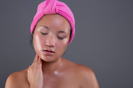 young woman of Chinese ethnicity taking care of her face with face creamの写真素材