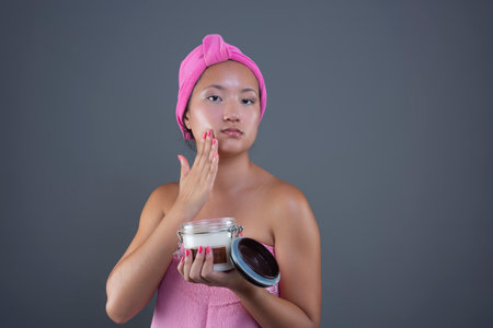 young woman of Chinese ethnicity taking care of her face with face creamの写真素材