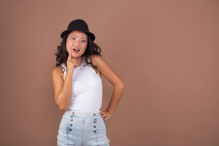 young woman, with hat making cute face isolated from the backgroundの写真素材