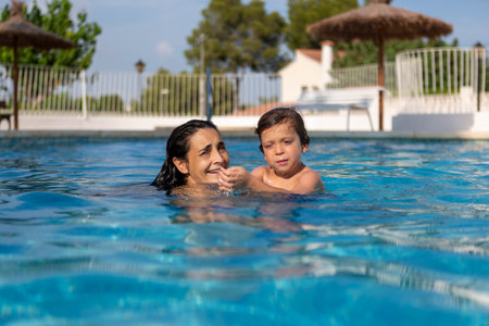 mother and son enjoying the poolの写真素材