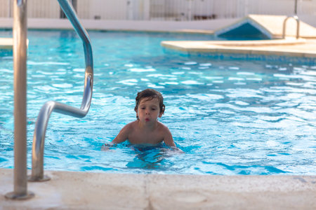beautiful boy enjoying swimming poolの写真素材