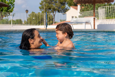 mother and son enjoying the poolの写真素材