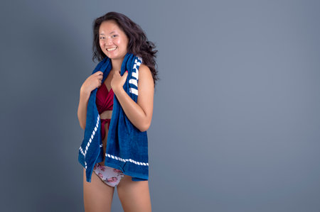 beauty asian ethnic woman in bikini with towel around her neckの写真素材