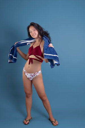 young asian ethnic woman in bikini with towel around her neckの写真素材