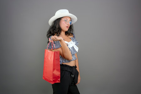 young asian girl with shopping bags and hatの写真素材
