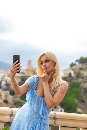 Graceful blonde woman in her 40s taking selfiesの写真素材
