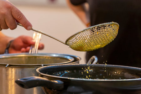 cook preparing and picking up freshly fried product with the frying pan paddle,の写真素材