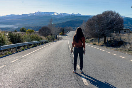 photo of woman seen from behind in the middle of the roadの写真素材