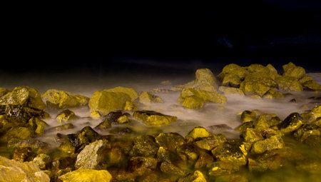 Rocky shoreline with waves photographed at lens shutter speedの写真素材