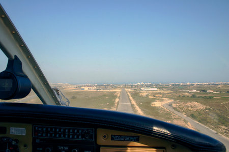 View from the cockpit of a plane to the city and the runwayの写真素材