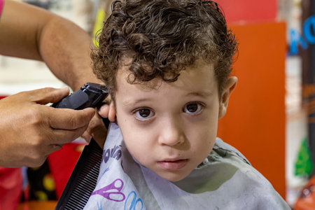Caucasian boy getting hairstyle in barbershop.の写真素材
