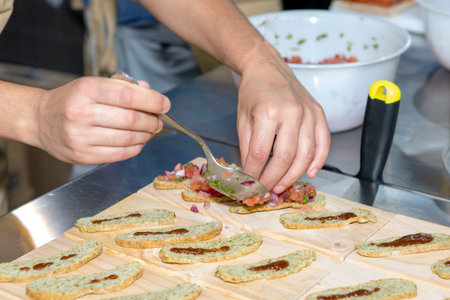 chef preparing spanish tapa on top of bread sliceの写真素材