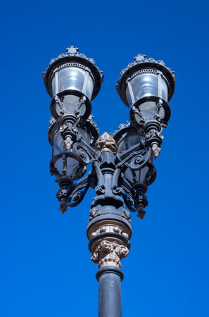 close up shot of old wrought iron street lamp, with four lampsの写真素材