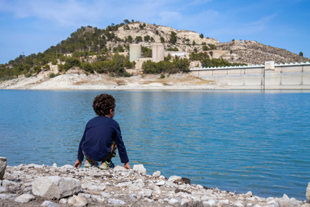 kid looking at the Amadorio dam located in Alicante, spainの写真素材