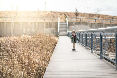 Boy playing in the park in Chicago during quarantine wearing a face maskの写真素材