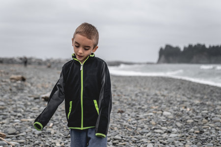 Young boy walking along Rialto Beach in National Park.の写真素材