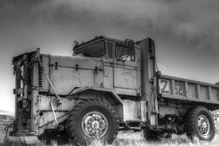 Abandoned dump truck in black and white with dramatic sky.の写真素材