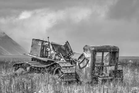Abandoned old vehicle in the field. Black and white photo.の写真素材