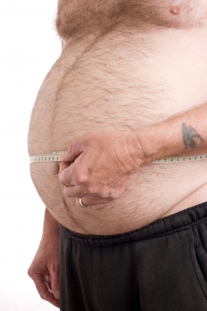 Obese male with measuring tape around stomachの写真素材
