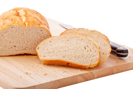 Bread sliced on chopping board with bread knife isolated on white 