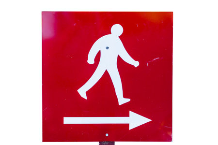 Red Metal directional sign, with white painted figure walking, and arrow pointing the way to the right, On white background の写真素材