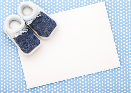 Baby invitation card with baby blue shoes and blue polka dot background.の写真素材