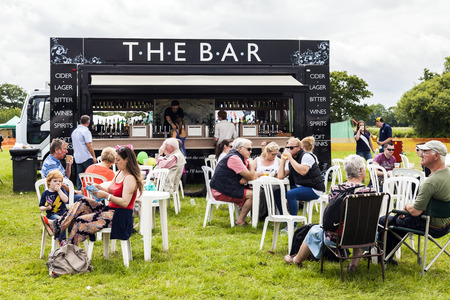 The Royal Cheshire County Show,  Knutsford , England, UK. - June 22, 2016  People of all ages drinking beverages from a mobile licensed bar in an open field at the The Royal Cheshire County Show Ground. Knutsford , England, UKのeditorial素材