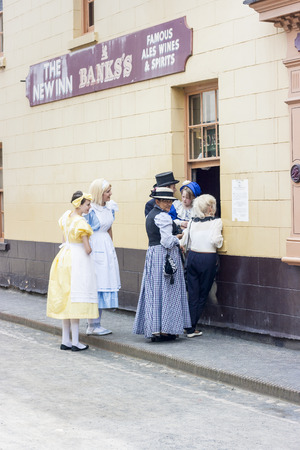IRONBRIDGE, ENGLAND - JULY 21 2012 : Performers from Alice through the looking glass on their break standing outside The New in pub at Blists Hill Working Museum,  a popular tourist attraction at  Ironbriidge, Shropshire, England.のeditorial素材