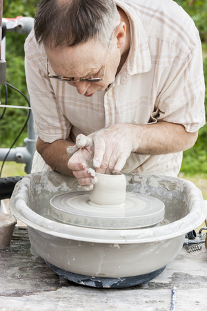 Stoke On Trent England - June 5 2011: Middle  aged man demonstrating his potting skills on a potters wheel at the Etruria Canals Festival, Stoke On Trent, Staffordshire, England.のeditorial素材