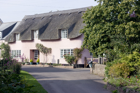 Somerset, England, UK- September 3 2010 : Typically English thatched cottage, Painted pink. Minehead, England, UK.のeditorial素材