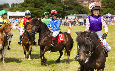 ENGLAND - 26th July 2014 - Leek & District Show.Children heading towards the starting line on their shetland ponies for Grand National qualifier.のeditorial素材