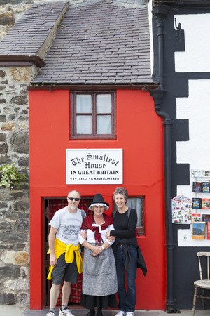 Conway, North Wales UK - May 18 2014 Tourists pose for picture with woman in traditional Welsh costume outside the smallest house in Great Britain.のeditorial素材