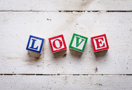 Abstract of old wooden floor boards with colourful toy blocks spelling the word LOVE conceptual ideas for valentines day.の写真素材