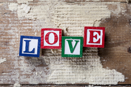 Abstract of old wooden floor boards with colourful toy blocks spelling the word "LOVE" conceptual ideas for valentines day.の写真素材