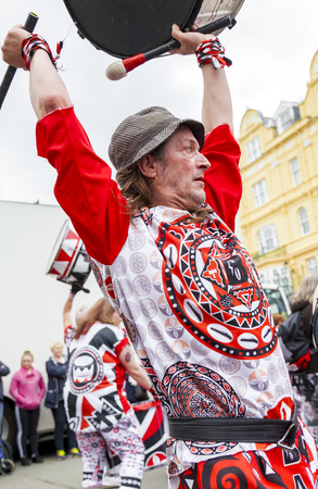 Llandudno, North Wales- 29th April 2017: Performers of the Batala Mersey carnival band  in Llandudno. Man in trilby fedora hat playing on a drum raised above his head.のeditorial素材