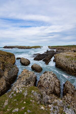 blue sea hitting the rocks with its waves in spainの写真素材