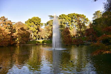 fountain over the lake in a leafy park in spainの写真素材