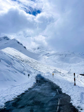 road in the snow between snowy mountains in spainの写真素材
