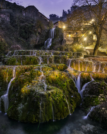 waterfall inside the village at night in the north of Spainの写真素材